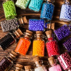 Colorful beads in small glass jars.