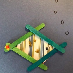 Craft Stick Fish - fish glued to a piece of blue paper with bubbles drawn on