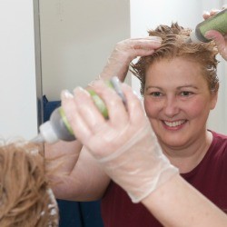 A woman dyeing her hair in her bathroom.