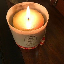 A burning candle that has been replaced in the candle holder.