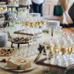 Stylish champagne glasses and food appetizers on table. 