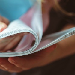 A person reading through a magazine.